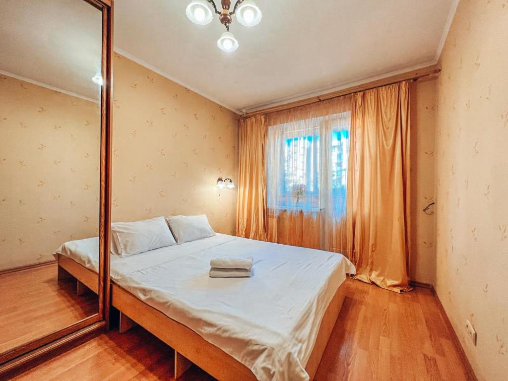 een slaapkamer met een groot bed en een spiegel bij Apartments near the Exhibition Centre in Kiev