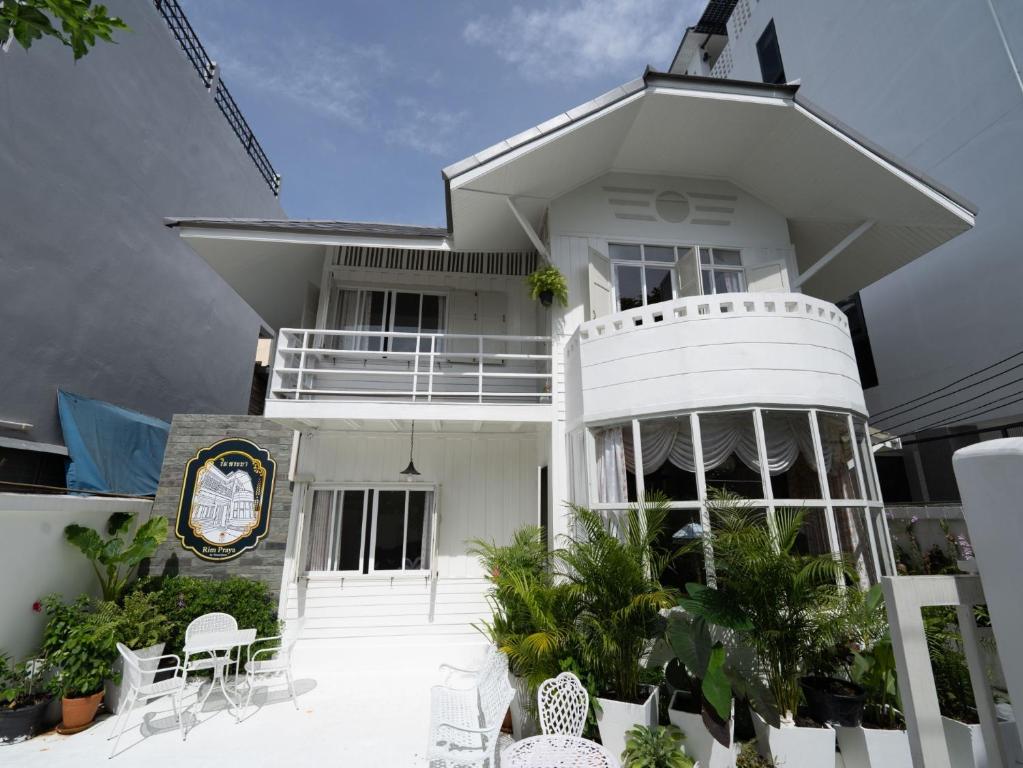 a white house with chairs and tables in front of it at RoomQuest Rim Praya Dinsor Road in Bangkok