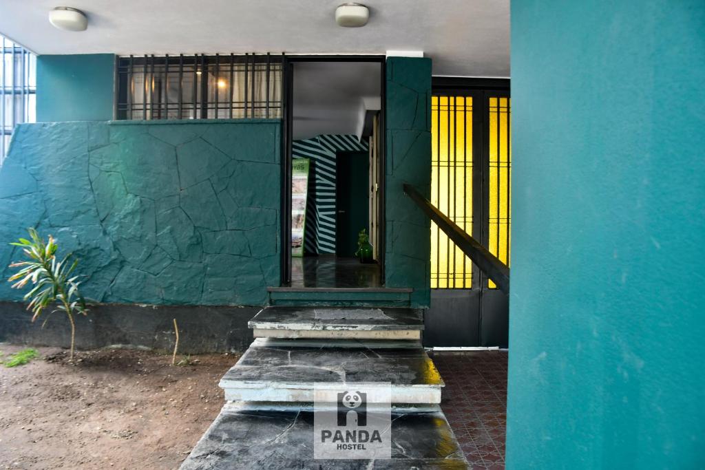 門多薩的住宿－Panda Hostel Mendoza，一座带蓝色墙壁的房子的前门