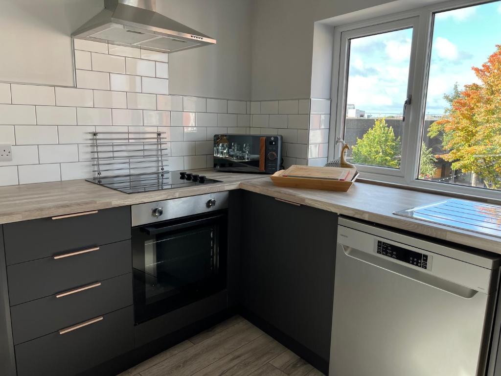 a kitchen with a counter with a stove and a window at The Upper Gathering - Sleeps Up To 9 in Sale