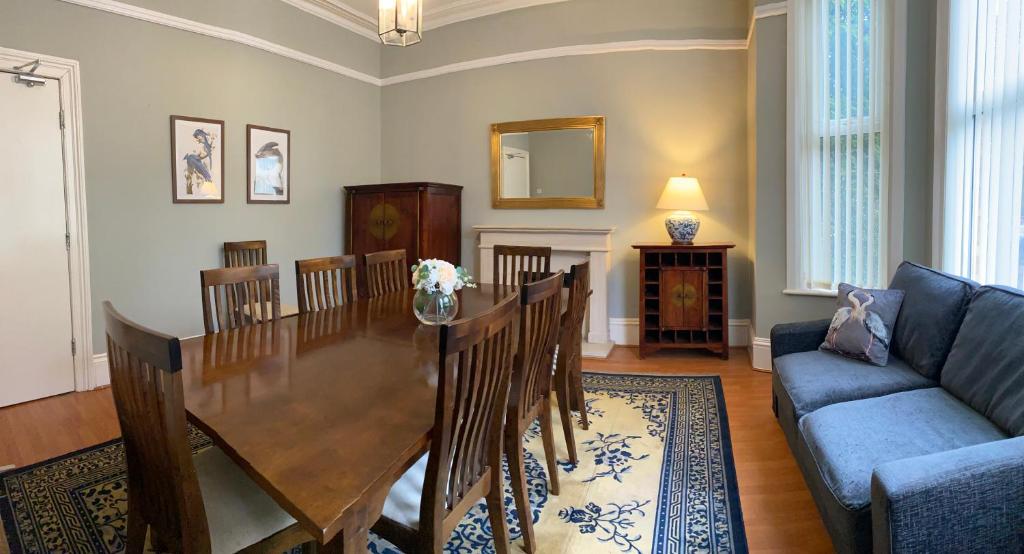 a dining room with a table and a couch at Villa with Park Views close to Liverpool Centre in Liverpool