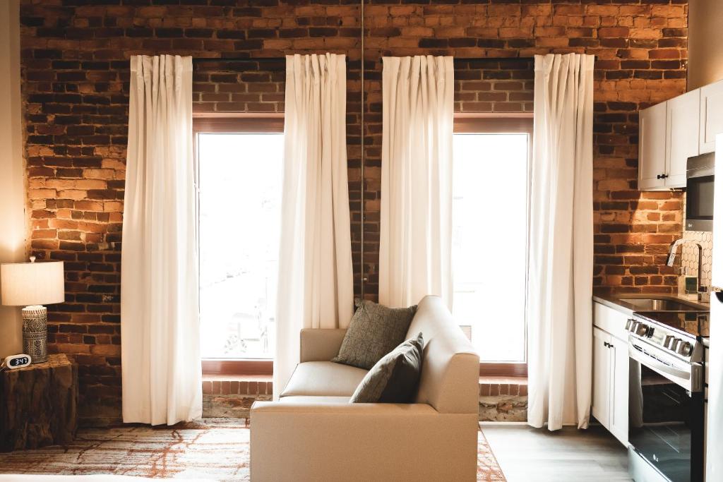 a living room with a couch and two windows at Three Trails in Elkin