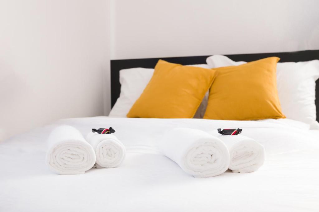 Una cama blanca con cuatro toallas enrolladas. en Stílusos lakás ingyenes parkolással, en Debrecen