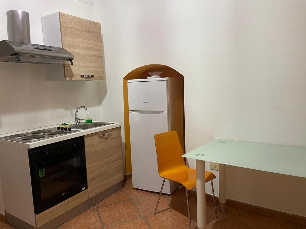 uma pequena cozinha com um frigorífico branco e uma mesa em Luxury Suite em Mesagne