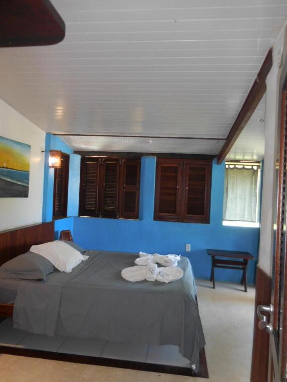 a bedroom with a bed with blue walls at Pousada Casa Canto das Águas in Icaraí