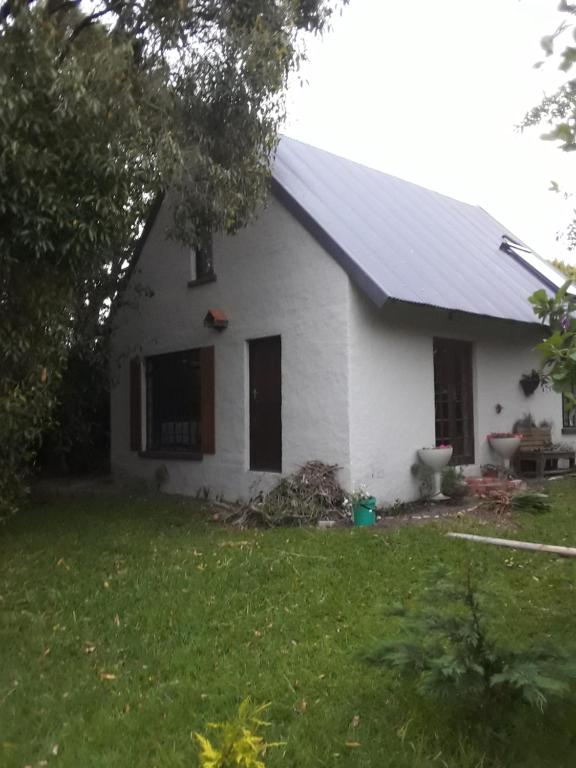 una casa blanca con un patio delante en Emerald Hill Cottage, en Mount Pleasant