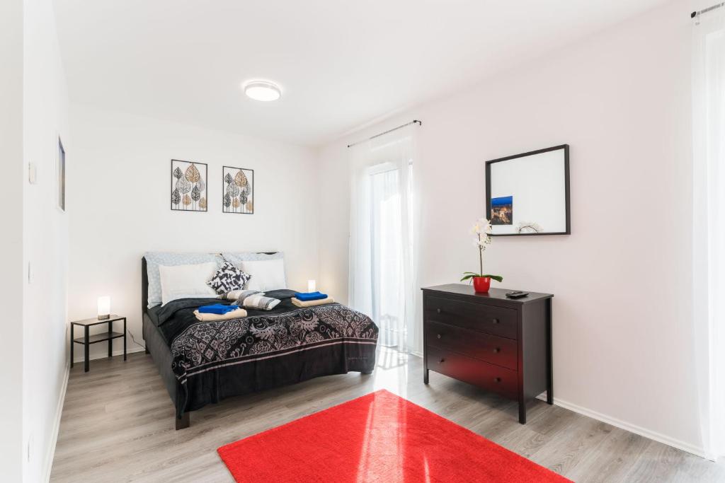 um quarto com uma cama e um tapete vermelho em New Blue Danube Apartment with Balcony and Parking em Budapeste