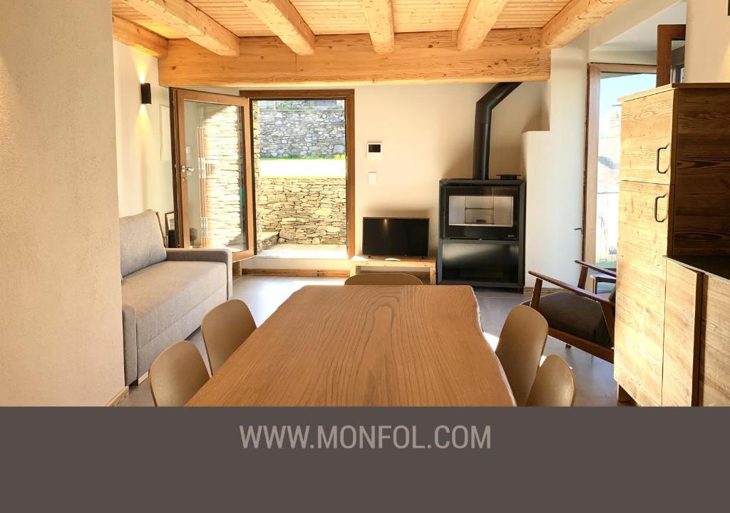 ein Wohnzimmer mit einem Holztisch und einem Sofa in der Unterkunft Chalet Del Sole in Monfol