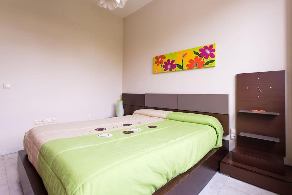 - une petite chambre avec un lit et une couverture verte dans l'établissement FIBES con parking gratis. Apartamento Sevilla Este., à Séville