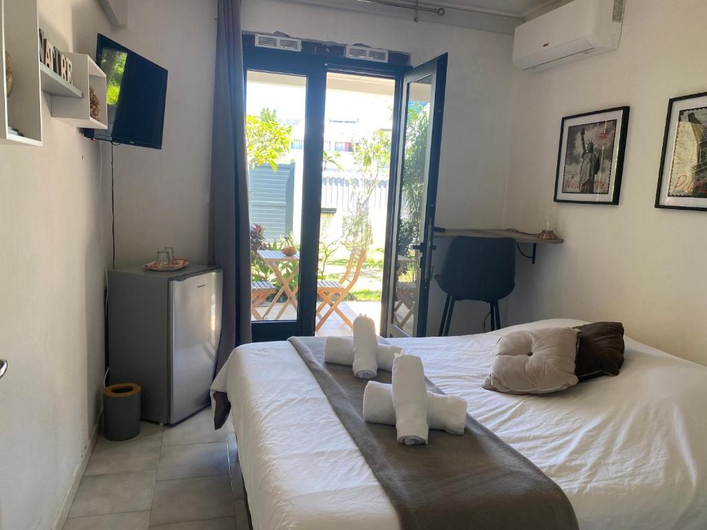 a bedroom with a bed with white towels on it at Ti kaz bo - Chambre Combava chez l'habitant in Bras-Panon