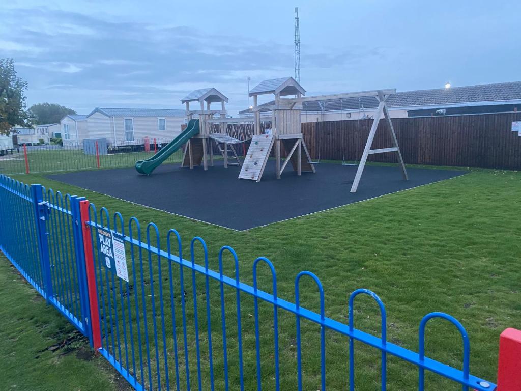 a playground with a slide and a swing set at L&g FAMILY HOLIDAYS MILLFIELDS 6 BERTH FAMILYS ONLY AND THE LEAD PERSON MUST BE OVER 30s in Ingoldmells