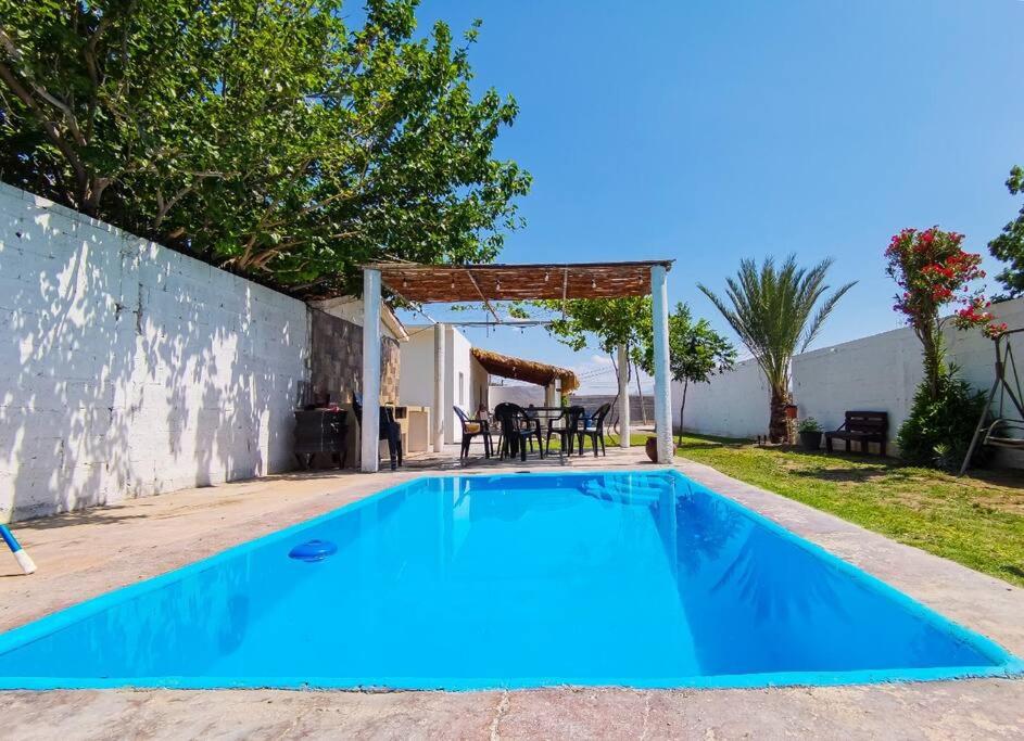 a blue swimming pool with a gazebo at Casa Ferriño in Cuatrociénegas de Carranza