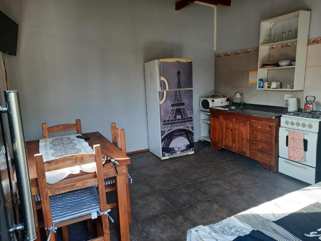een keuken met een koelkast, een tafel en een fornuis bij Mardifiore 3 in General Juan Madariaga