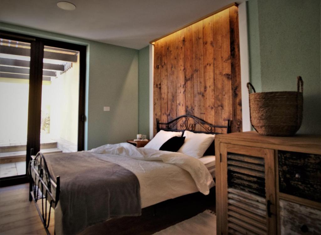 1 dormitorio con 1 cama y pared de madera en Olivea, en Dobrovo