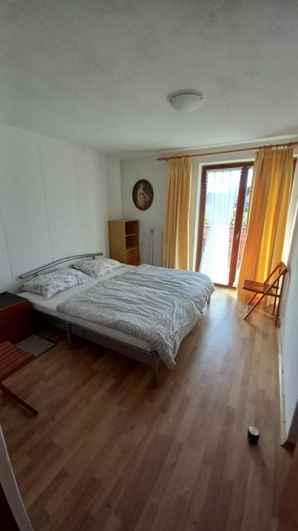 1 dormitorio con 1 cama y suelo de madera en Draga - 2 bedroom apartment, en Tržič
