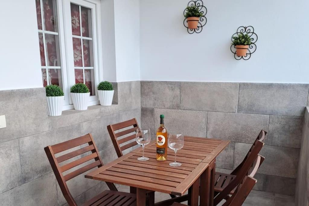 - une table en bois avec une bouteille de vin et des verres dans l'établissement Casa Mar y Lava, à El Golfo