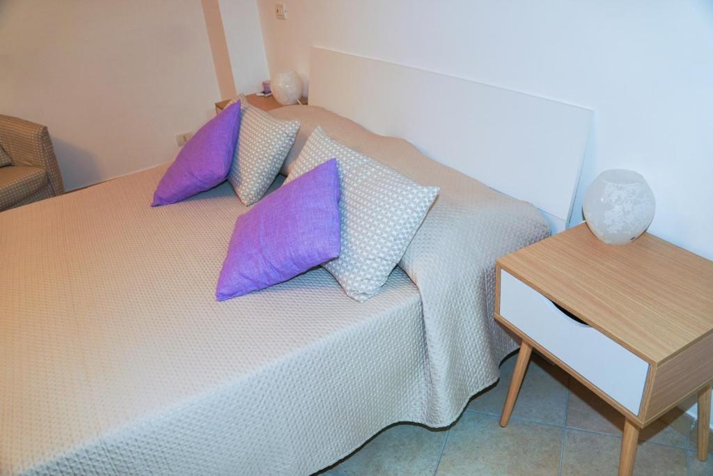 a bedroom with a bed with purple pillows on it at IL GLICINE in Sorrento