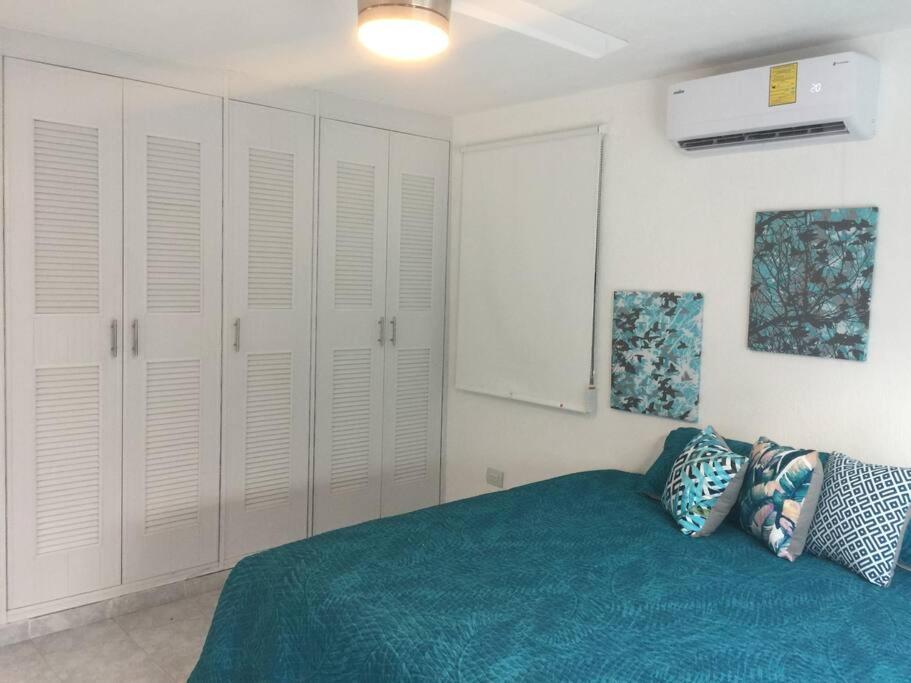 a bedroom with white cabinets and a blue bed at Casa Monik, a dos pasos de la Playa in Cancún