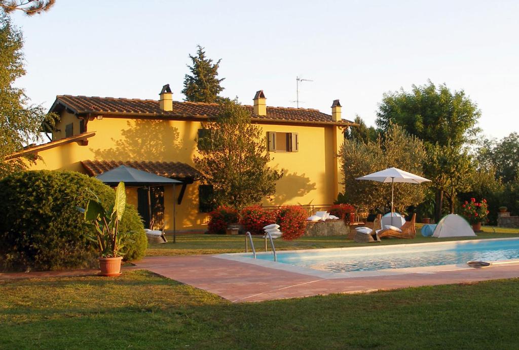 una casa amarilla con piscina frente a ella en La Casa di Agata Deluxe, en Fucecchio