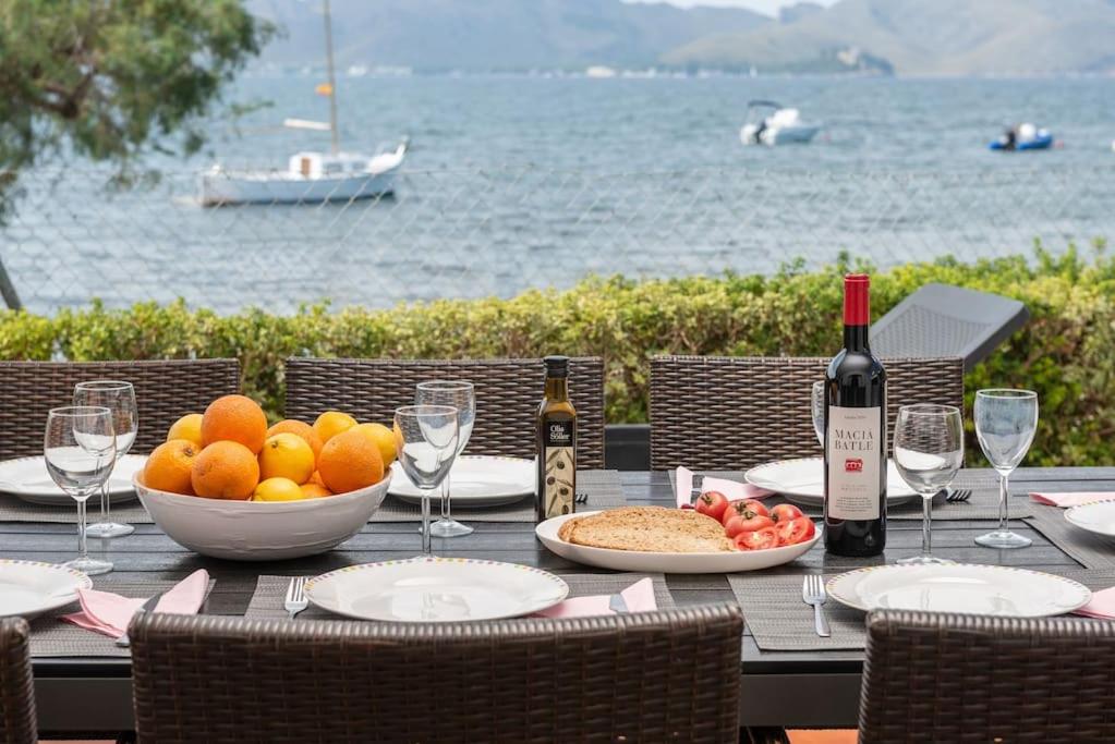 a table with a bowl of fruit and wine bottles at SES ONES with sea views in Alcudia