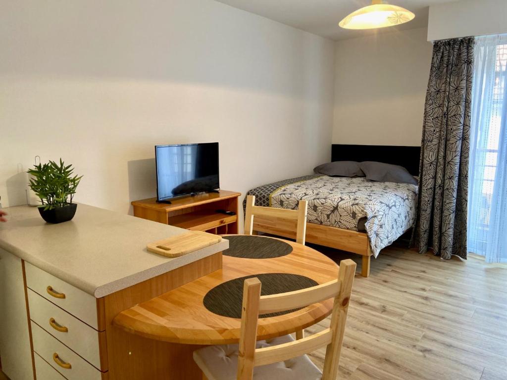 Habitación pequeña con cama y escritorio con sidra de mesa en Studio le pied de Bœuf en Wissembourg