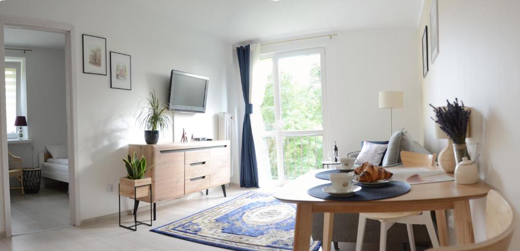 ein weißes Wohnzimmer mit einem Tisch und einem Sofa in der Unterkunft Między Parkami in Sandomierz