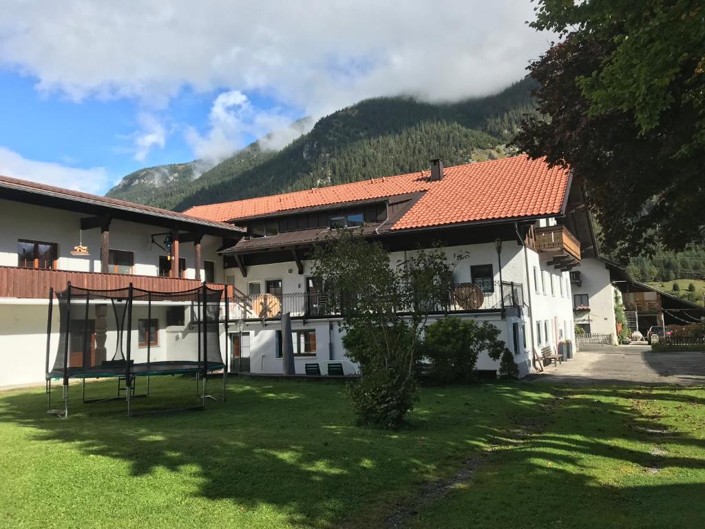 une maison avec un panier de basket dans la cour dans l'établissement Pony-Ziegen-Hasen-Ranch Bichlbach, à Bichlbach