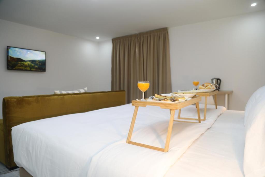 ein Hotelzimmer mit einem Bett und einem Tisch mit Weingläsern in der Unterkunft MJI GROUP in Tan-Tan