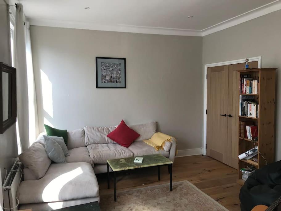 uma sala de estar com um sofá e uma mesa em Elegant 3bed Crouchend in style with roof terrace em Londres