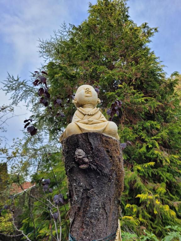 a statue of a person in a tree stump at Le Relais De L&#39;Aube in Villers-Bretonneux