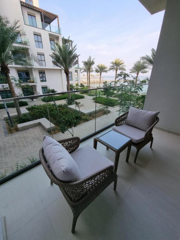 een balkon met 2 stoelen, een bank en een tafel bij Shaqa at Address Beach Residence - Fuj in Fujairah