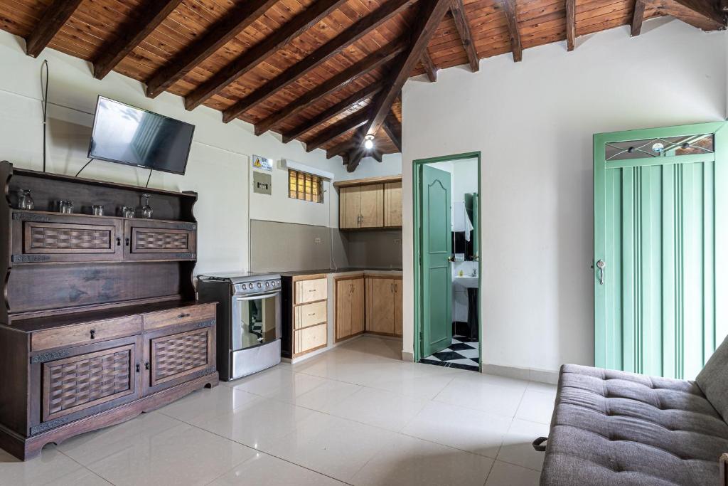 a kitchen with a stove and a couch in a room at Soy Local Guatape in Guatapé