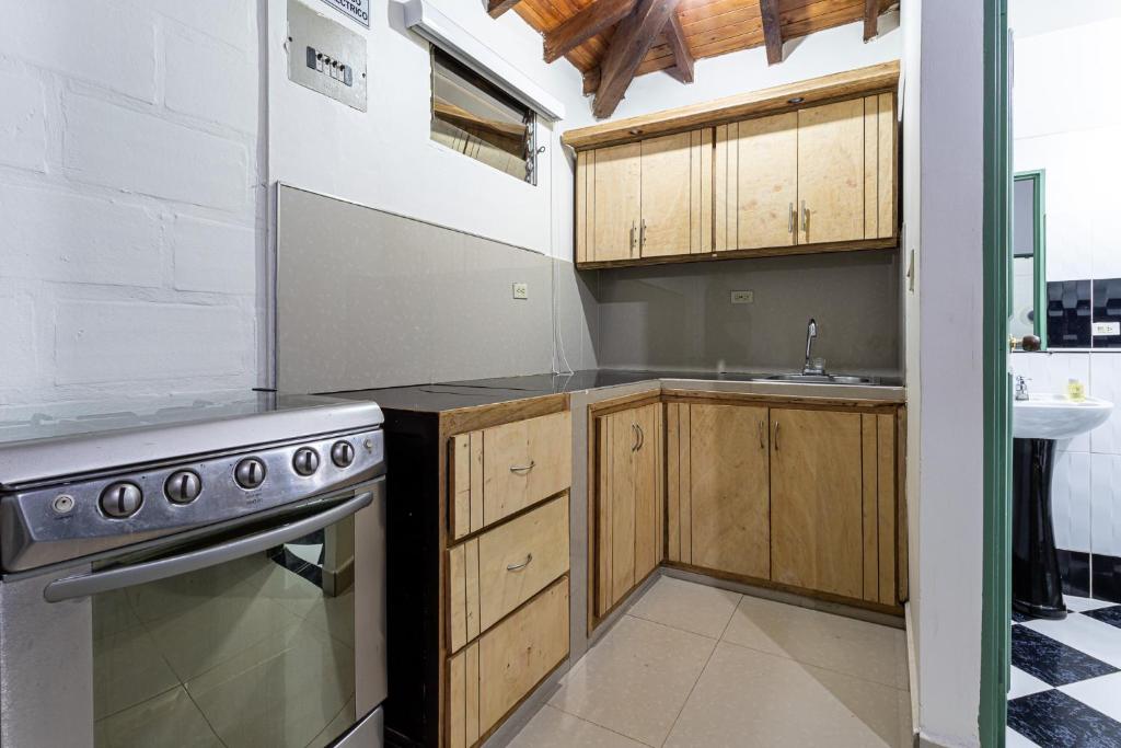 a kitchen with wooden cabinets and a stove at Soy Local Guatape in Guatapé