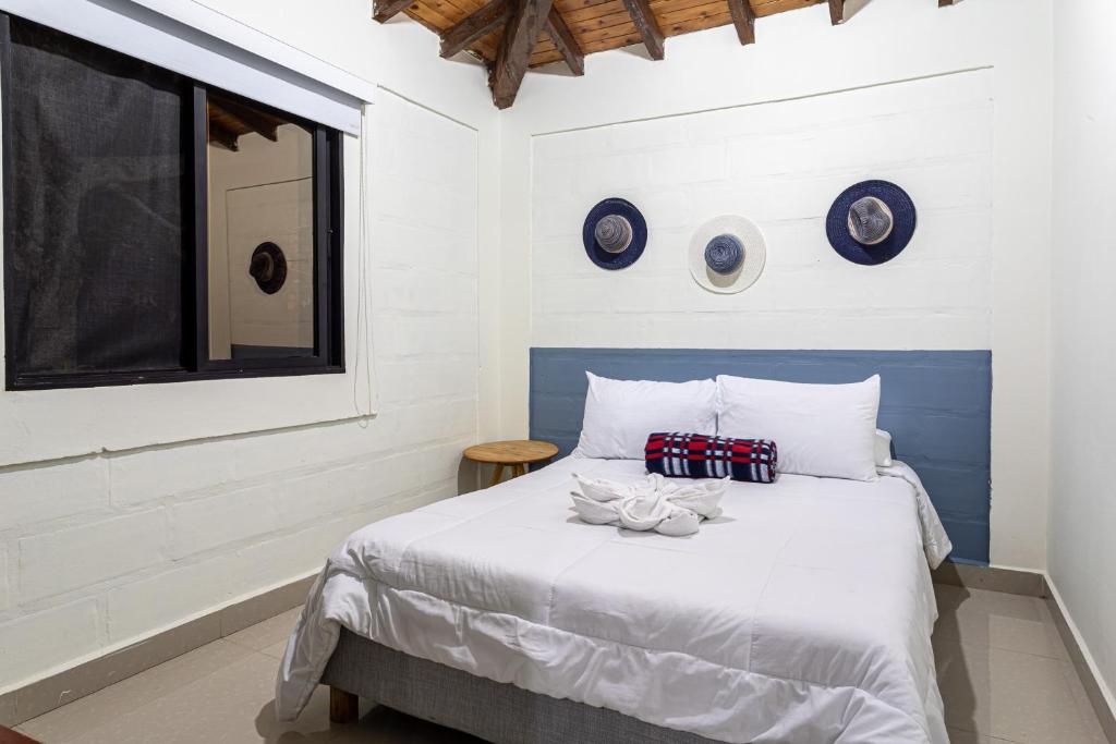 a bedroom with a bed with blue and white walls at Soy Local Guatape in Guatapé