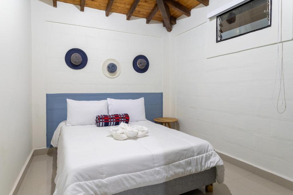 a bedroom with a white bed with two bowls on it at Soy Local Guatape in Guatapé