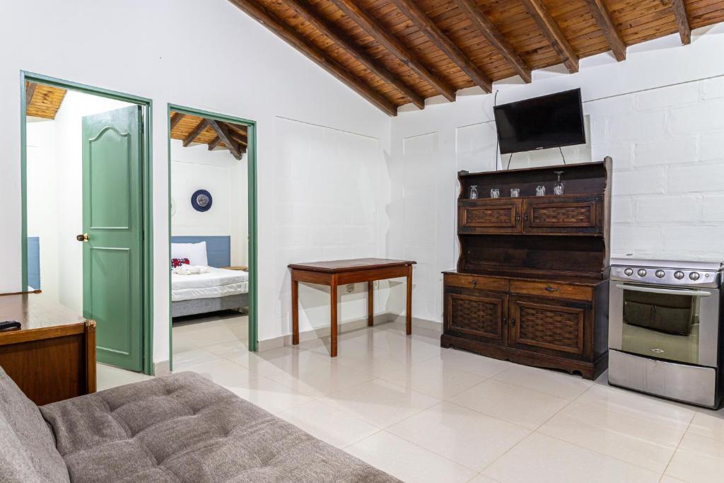a living room with a couch and a tv on the wall at Soy Local Guatape in Guatapé