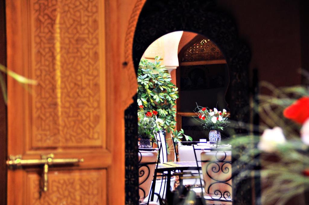 um quarto com uma mesa com flores e uma porta em Riad Bensaid em Marrakech