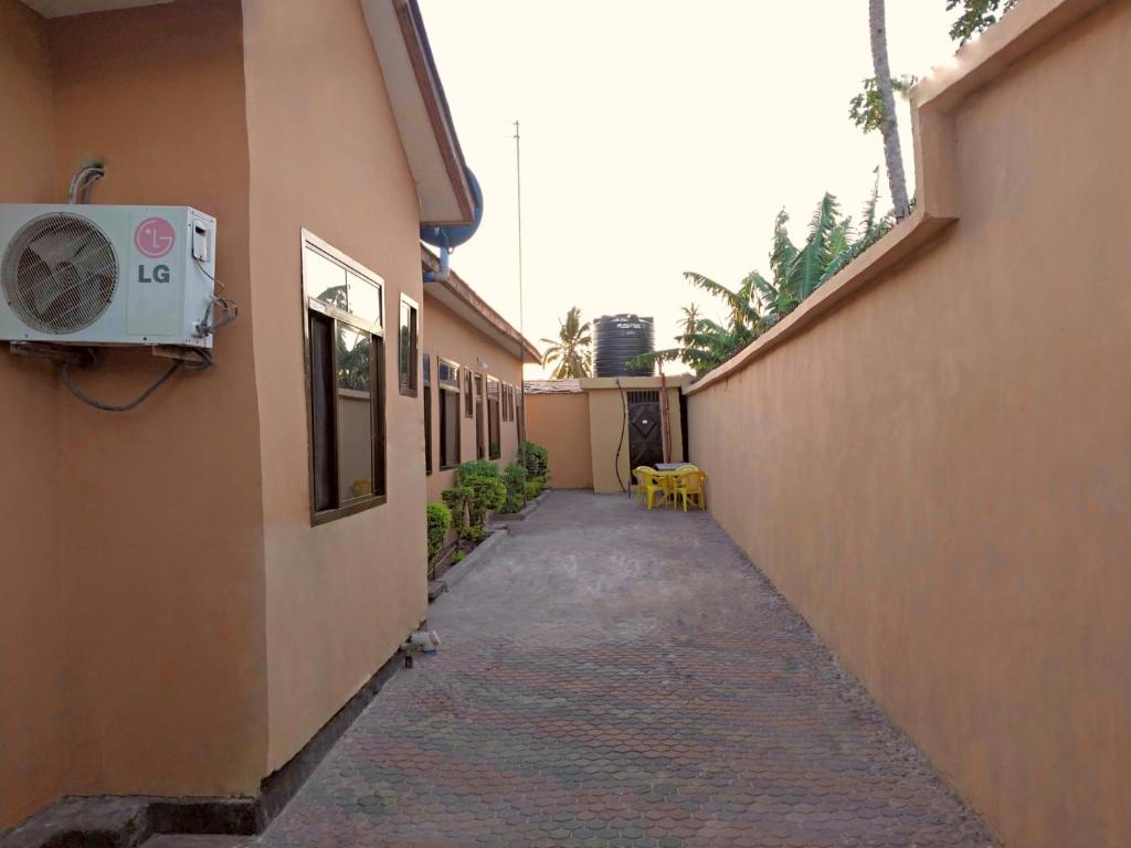 un callejón entre dos edificios con aire acondicionado en California Lodge en Bagamoyo
