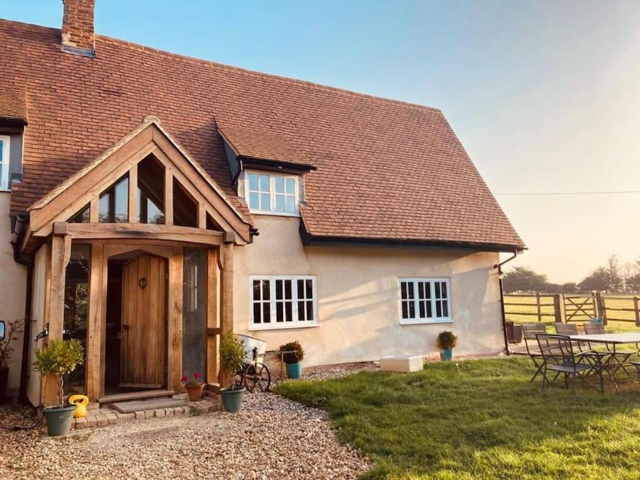 a house with a wooden door and a table at 2 Beds & living in our idyllic country Cottage in Bedford