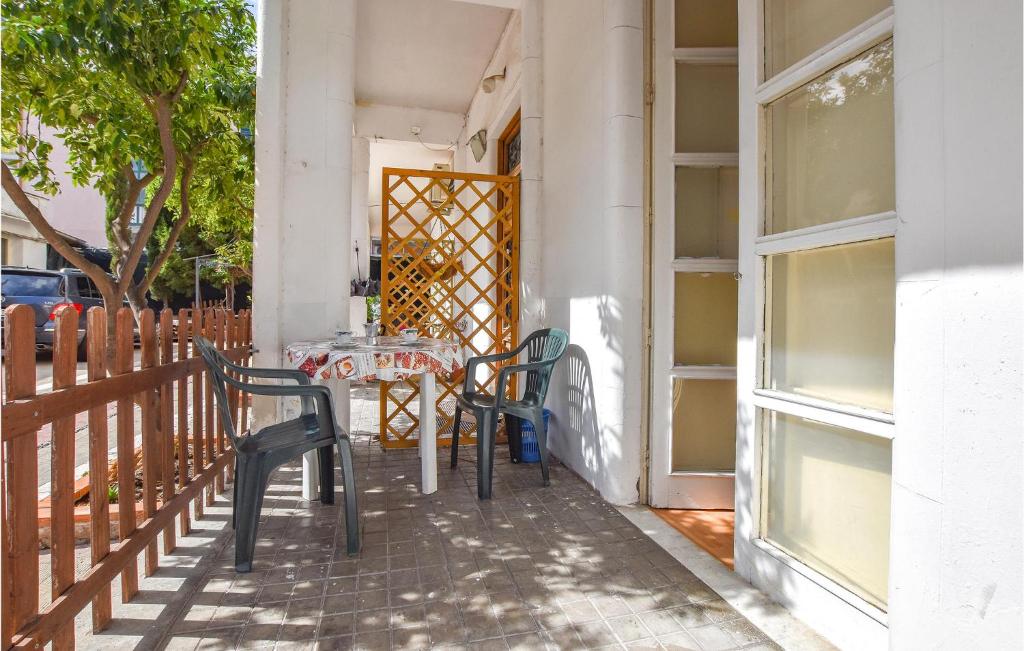 a table and chairs on the porch of a house at 1 Bedroom Pet Friendly Apartment In Acireale in Acireale