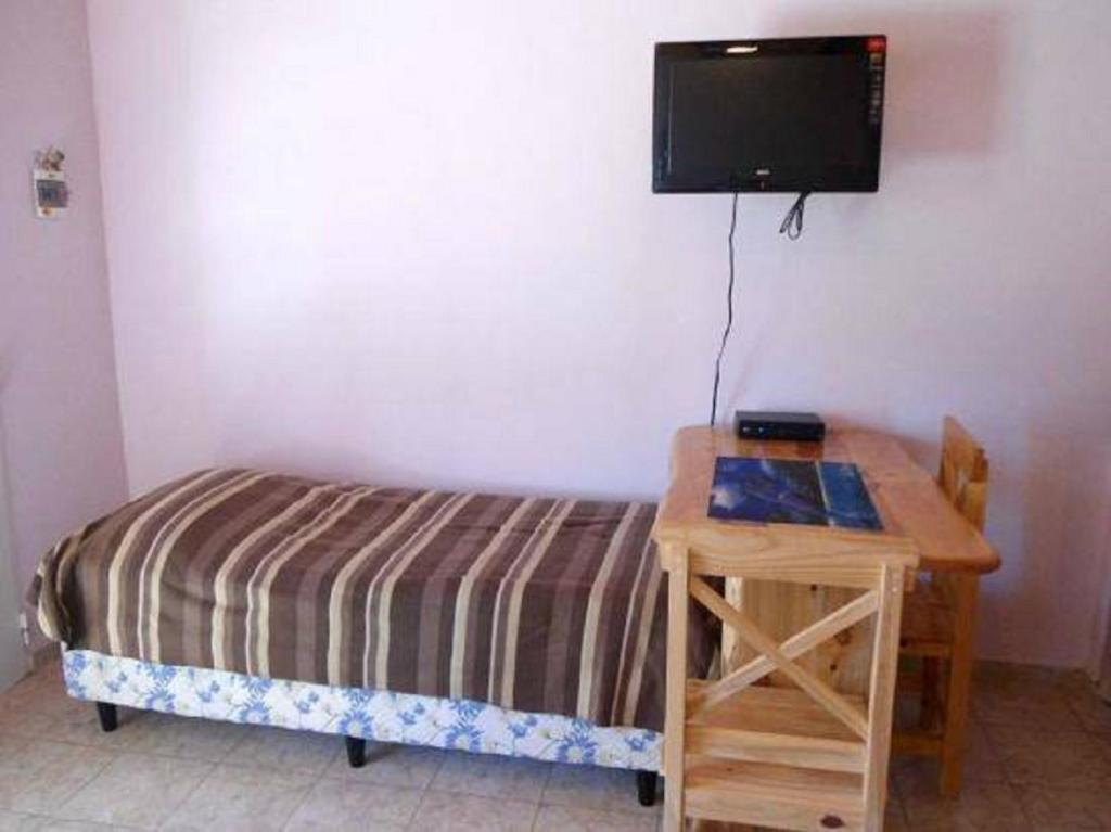 a bedroom with a bed and a desk with a television at Cabañas Comarca del Colorado in Río Colorado
