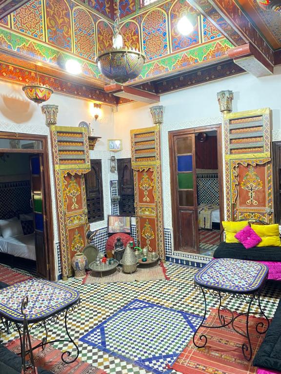 uma sala de estar com um sofá e uma mesa em Dar Chourouk em Fez