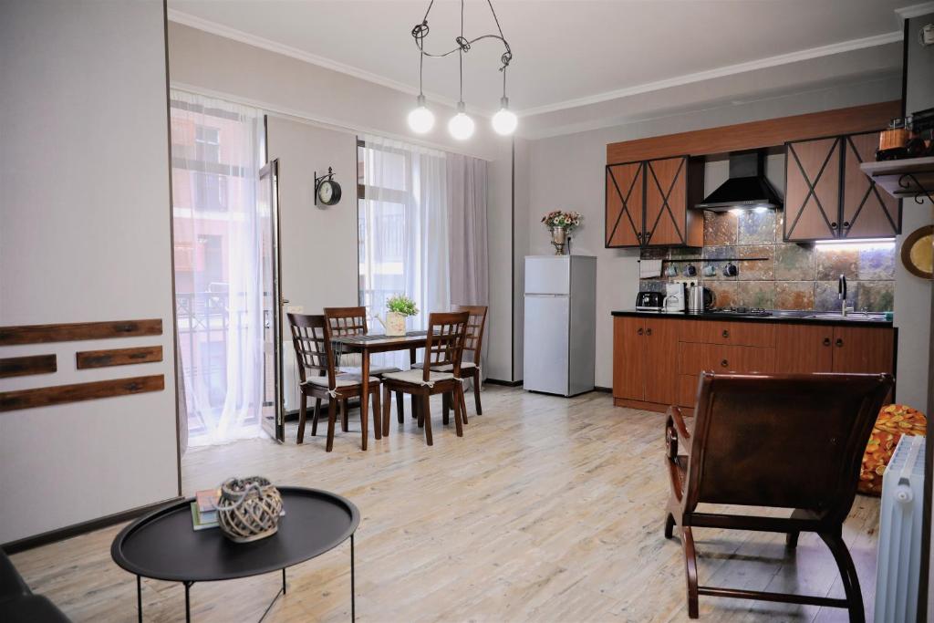 Una cocina y una sala de estar con mesa y sillas. en Avlabari Apartment - NEW ONE, en Tiflis