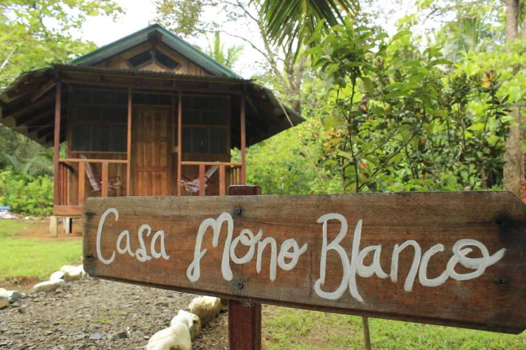 a sign in front of a house with a sign at Sabalo Lodge Tours and Cabins in Sierpe