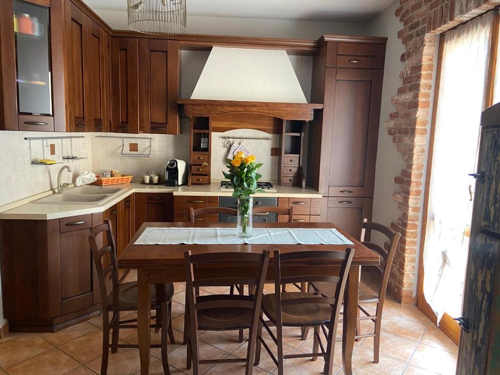 a kitchen with a wooden table and chairs at Casa Luisini in Mondovì