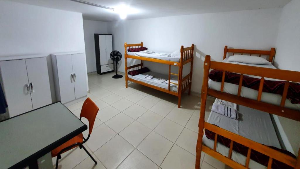 a room with a table and two bunk beds at Hostel Airport Rooms in Sao Paulo