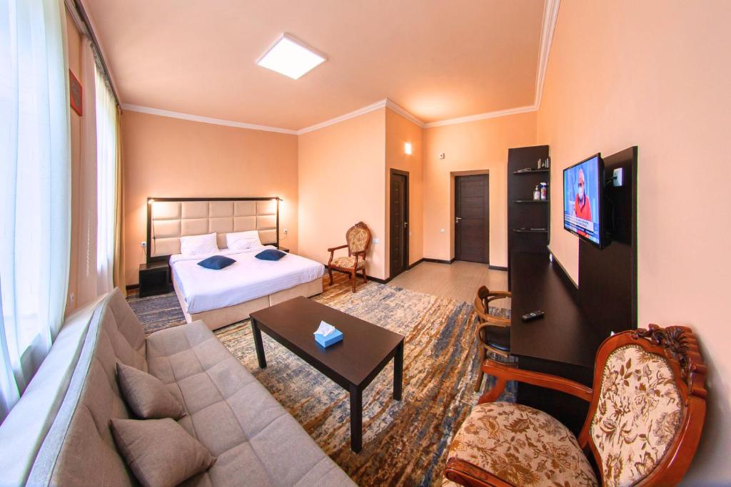 Habitación de hotel con cama y sala de estar. en Vanadzor Armenia Health Resort & Hotel, en Vanadzor