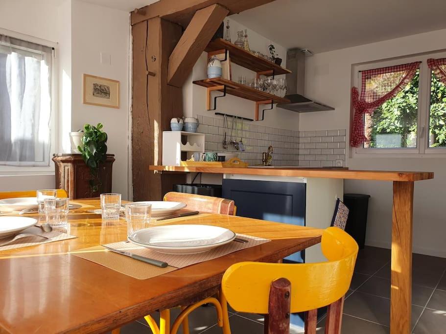 a kitchen with a wooden table and yellow chairs at Pavillon d&#39;Aÿ cottage Champagne - Label Green Key in Ay