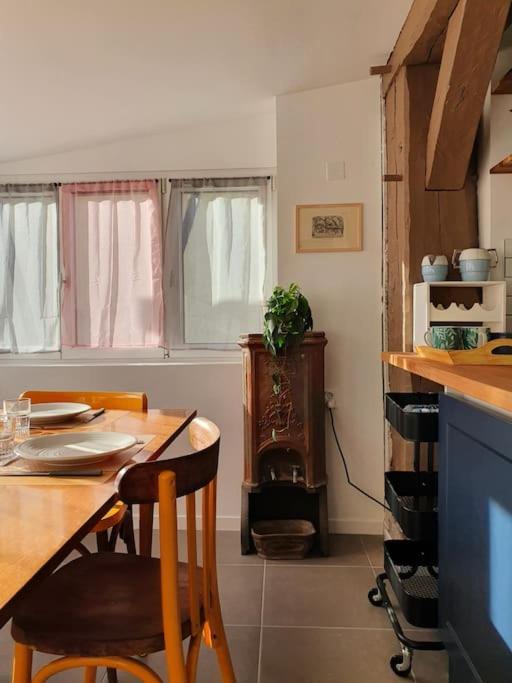 a kitchen with a table and chairs and a stove at Pavillon d&#39;Aÿ cottage Champagne - Label Green Key in Ay