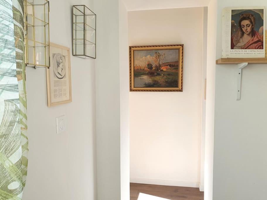 a hallway with a painting on the wall and a picture at Pavillon d&#39;Aÿ cottage Champagne - Label Green Key in Ay